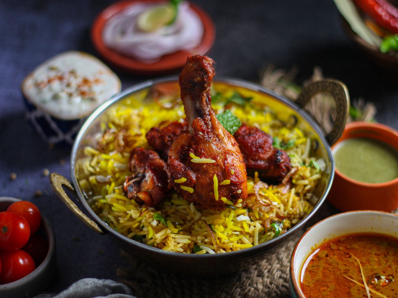 Flavorful chicken biryani with herbs and spices served in a traditional brass bowl, capturing the essence of Indian cuisine.